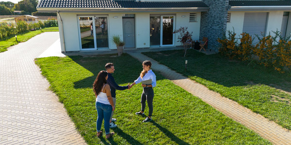 hombuyers meeting with a realtor in front of a house