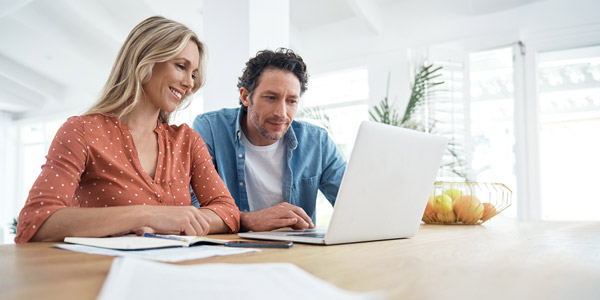 couple reviewing paperwork on laptop