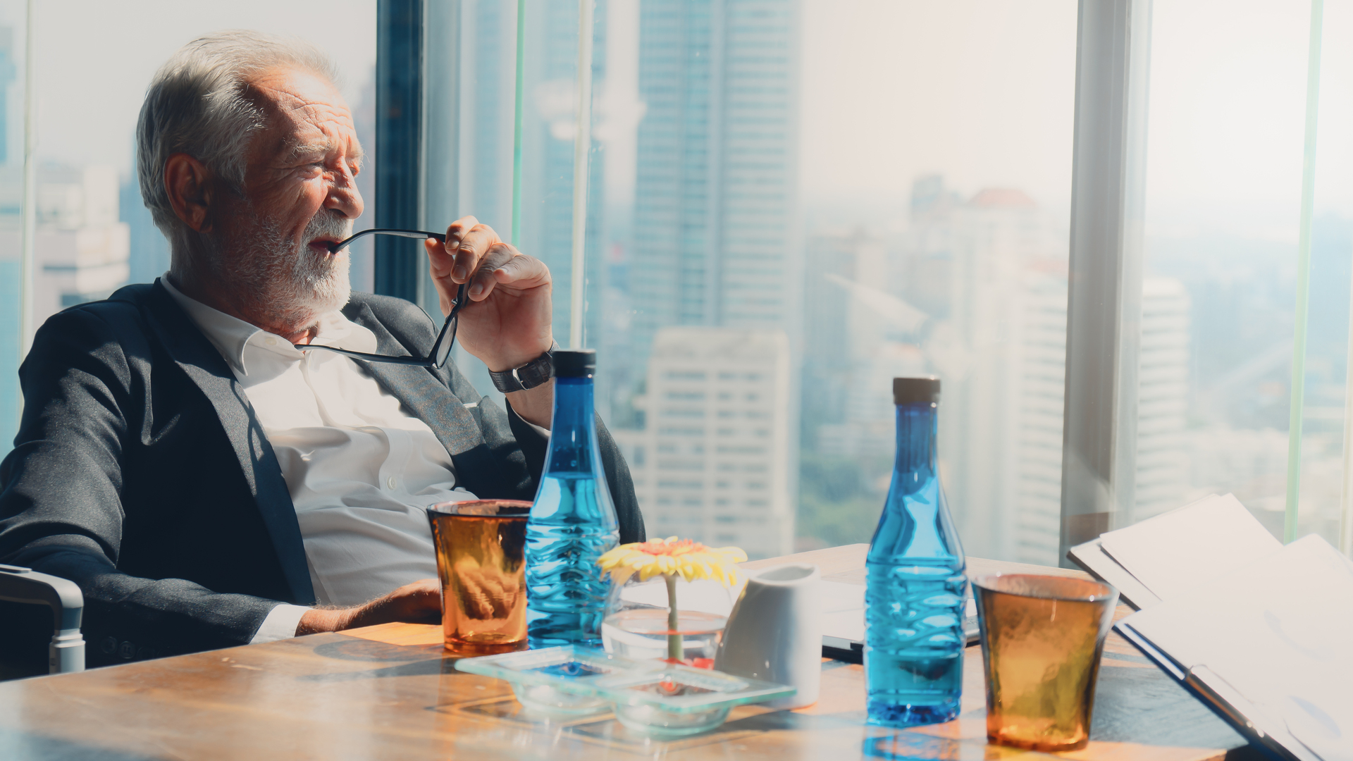 senior executive sitting by office window thinking of business strategy of company