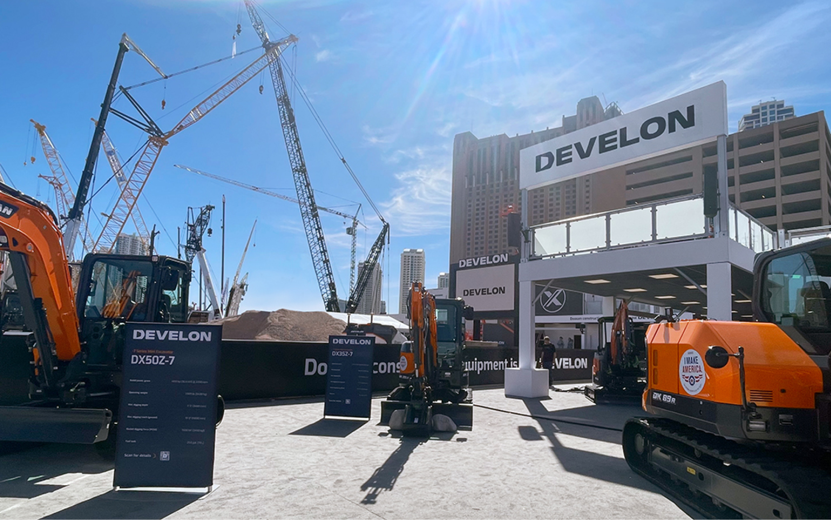 Multiple heavy equipment machines at the DEVELON CONEXPO 2023 outdoor booth.