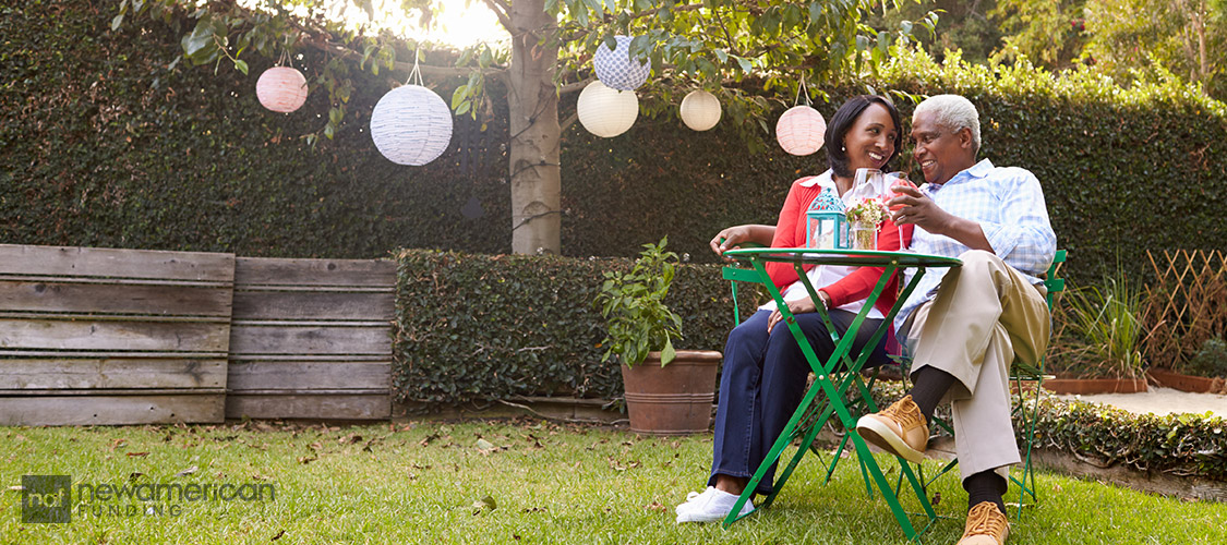 mature black couple sitting close together in yard