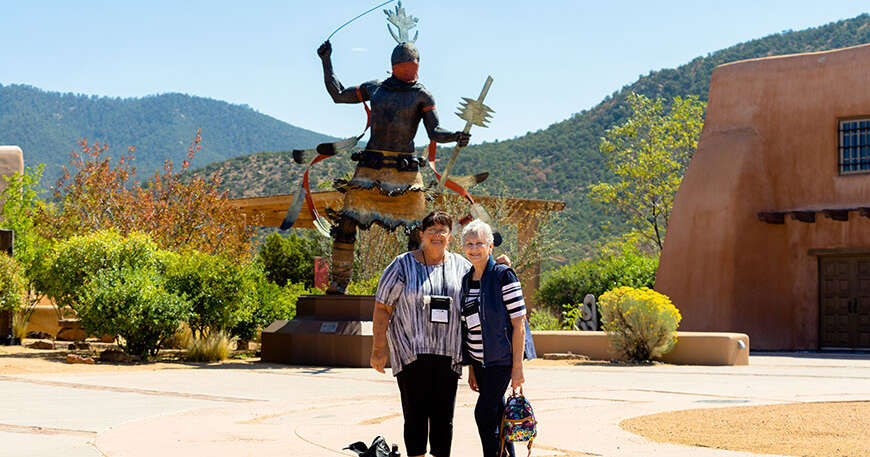 Two women stand in front of a large statue at a Santa Fe museum in New Mexico while learning about Conversos and Crypto-Jews.