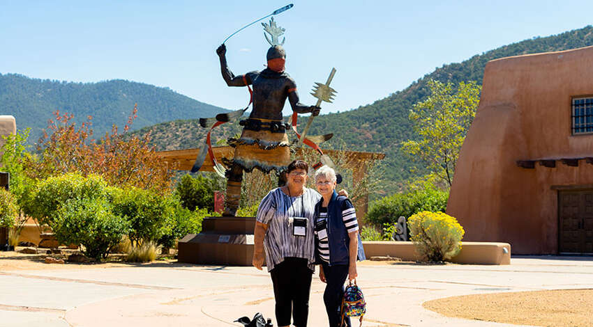 Two women stand in front of a large statue at a Santa Fe museum in New Mexico while learning about Conversos and Crypto-Jews.