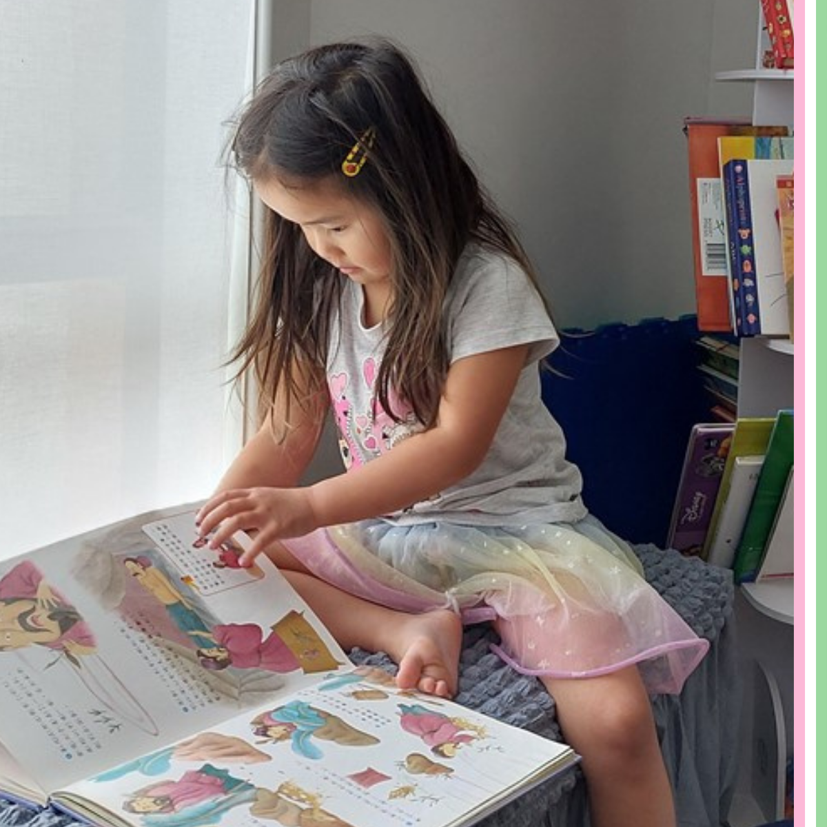 A young female child sit on her bend reading a picture book 