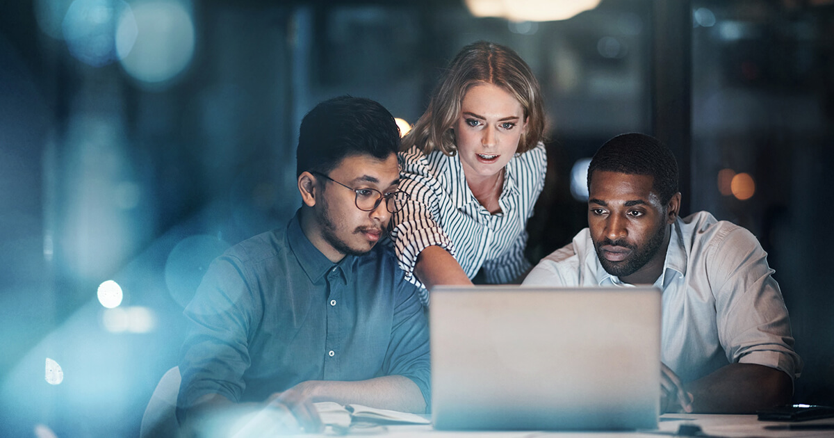 Three people looking at laptop computer.