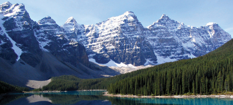 Snow-capped peaks of the Canadian Rockies reflect in the turquoise waters of a lake in Banff National Park, Alberta.