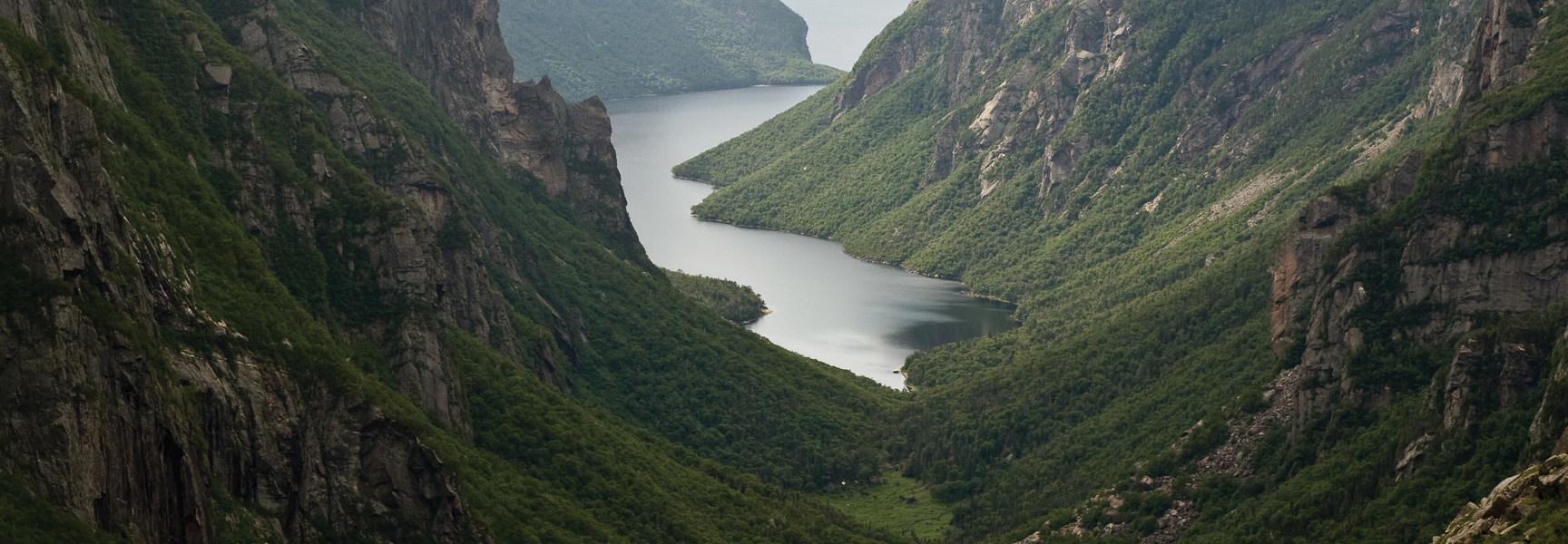 A dramatic view of a fjord cutting through the lush, steep mountains of Gros Morne National Park in Newfoundland and Labrador.