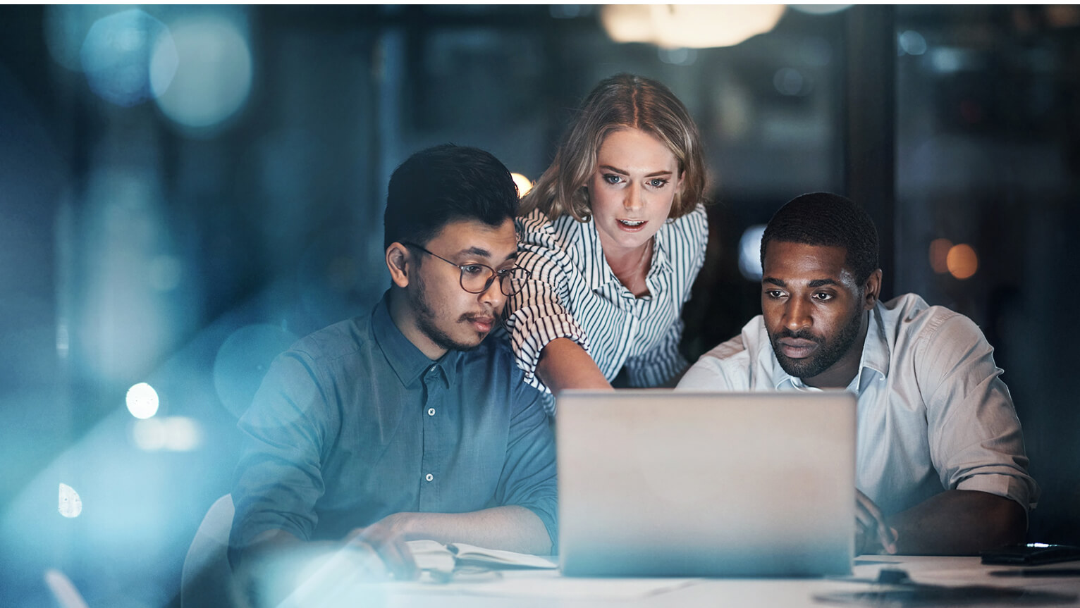 Three people looking at laptop computer.