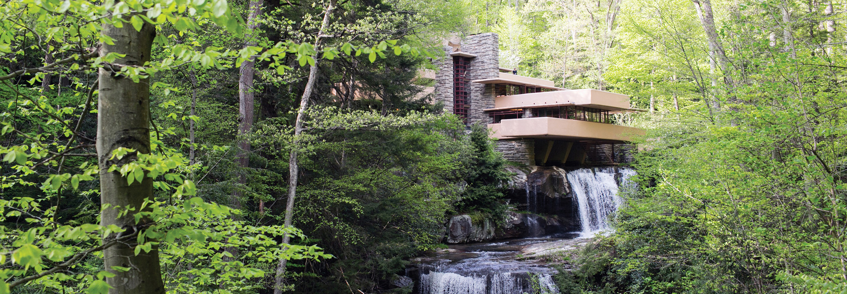Frank Lloyd Wright's Fallingwater house in Pennsylvania sits nestled in a forest, cantilevered over a cascading waterfall.
