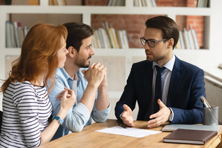 A couple discussing something with a man in a suit