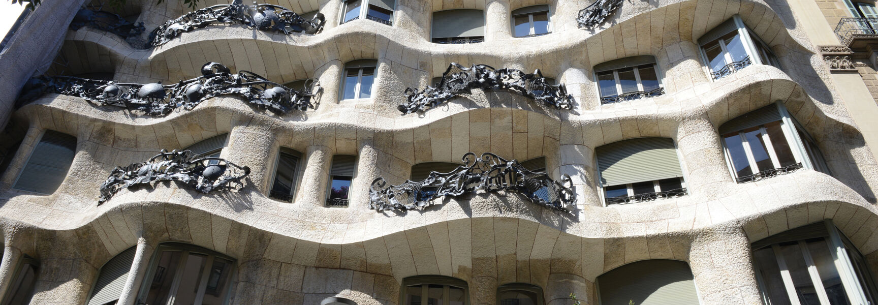 The wavy stone facade and intricate iron balconies of Casa Milà showcase the bold architecture found in Barcelona, Spain.