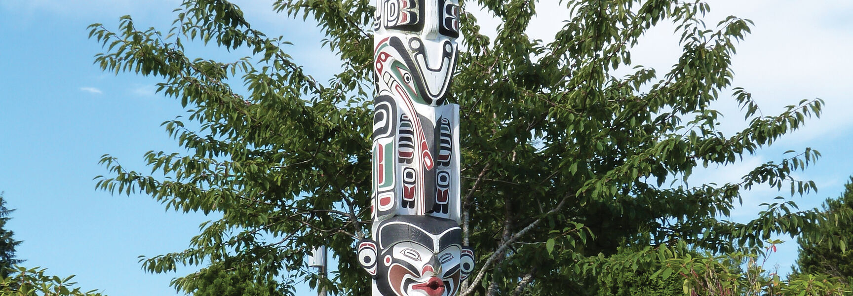 A tall, carved First Nations totem pole representing ancient cultures and traditional ways of life in British Columbia, Western Canada.