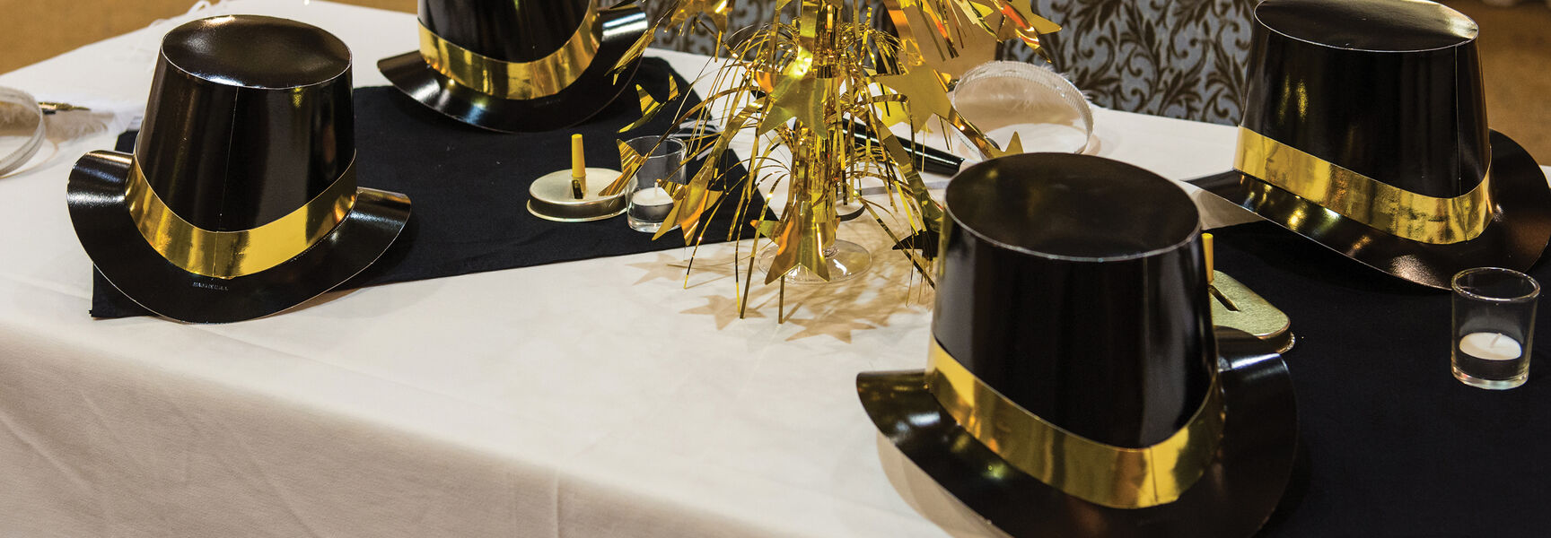 Black top hats and a gold star centerpiece decorate a table for New Year's Eve festivities at the Jekyll Island Club in Georgia.