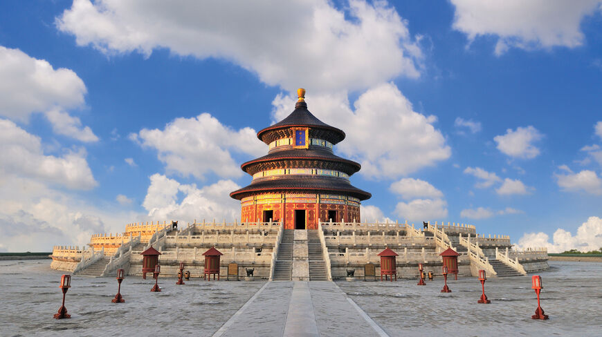 The Hall of Prayer for Good Harvests at the Temple of Heaven in Beijing, China, under a bright blue sky with scattered white clouds.