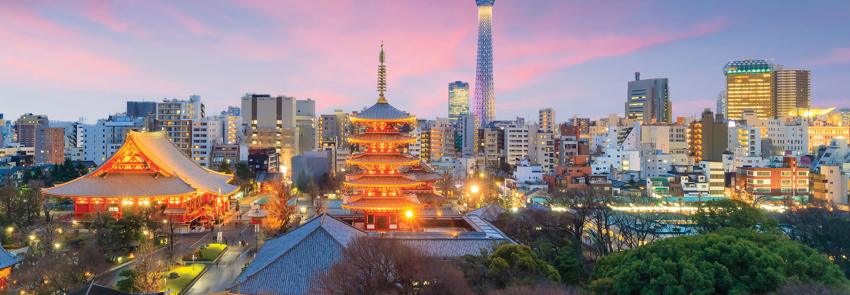 The illuminated Senso-ji Temple and pagoda in Tokyo, Japan, contrast with the modern Tokyo Skytree under a colorful sunset sky.