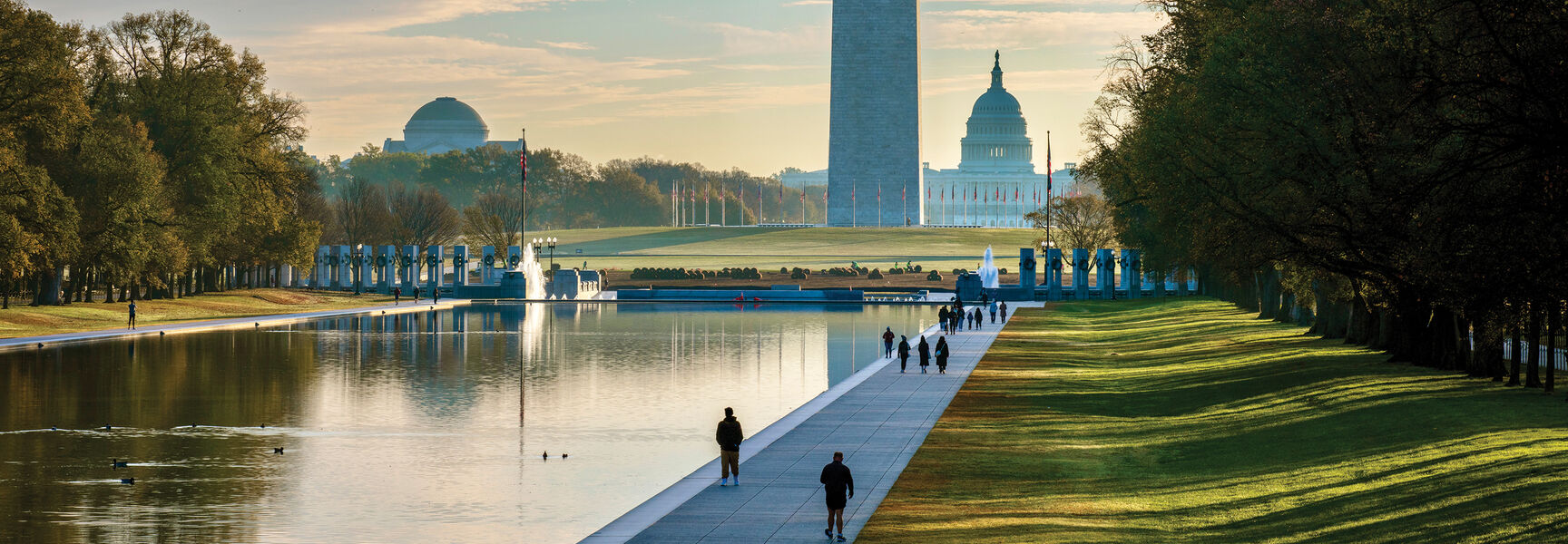 A scenic view of the Washington Monument and U.S. Capitol Building across the Lincoln Memorial Reflecting Pool in Washington, D.C.