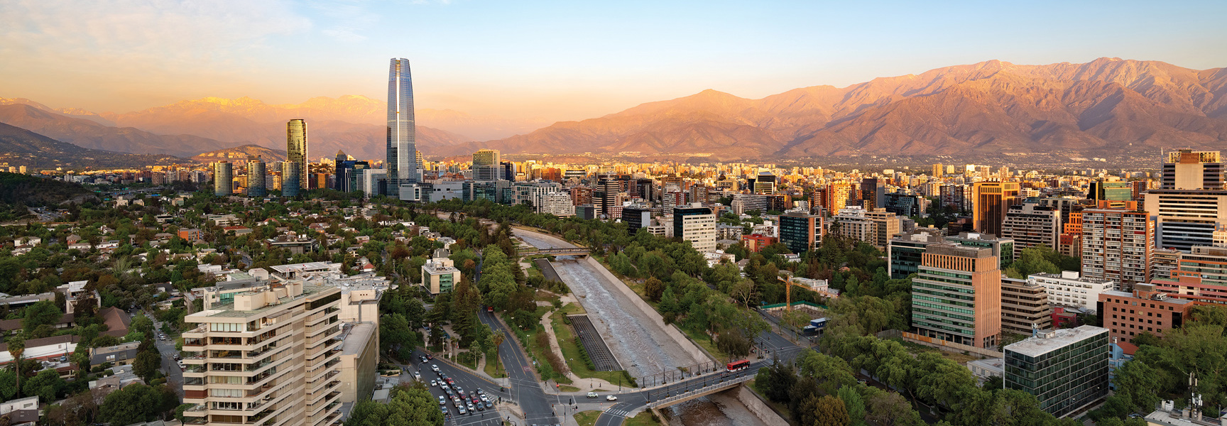 A sprawling cityscape of Santiago, Chile, nestled against the Andes mountains at sunset.