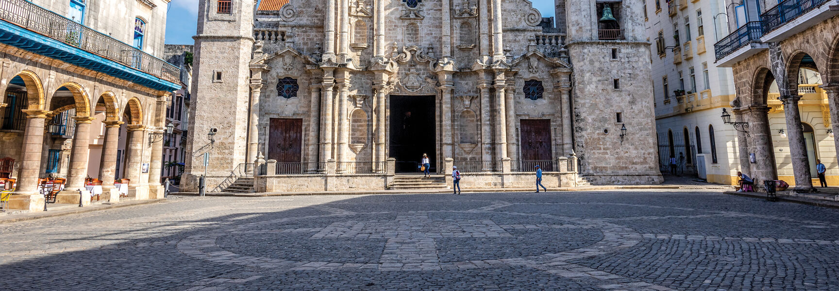 The historic Havana Cathedral features ornate Baroque architecture and asymmetrical bell towers overlooking a cobblestone square in Havana, Cuba.