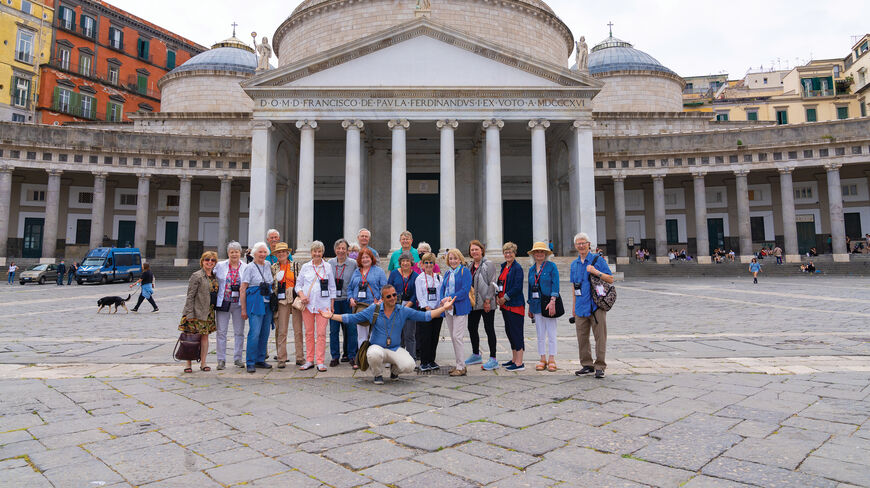 A group of travelers poses in Naples, Italy, in front of the San Francesco di Paola church in the Piazza del Plebiscito.
