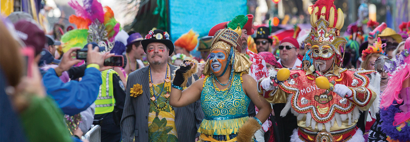 Vibrant participants in elaborate costumes and face paint march in a parade, illustrating sacred rituals of movement in contemporary life.