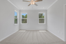 primary bedroom with windows and carpet