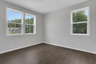 secondary bedroom with hard surface floors and windows