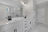 secondary bathroom with white cabinets and tile flooring