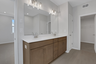 primary bathroom with wood cabinets and tile flooring 