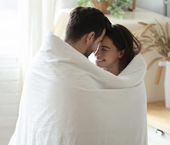 Mlad par uživa miren trenutek v varnosti, ki jo nudi življenjsko zavarovanje.