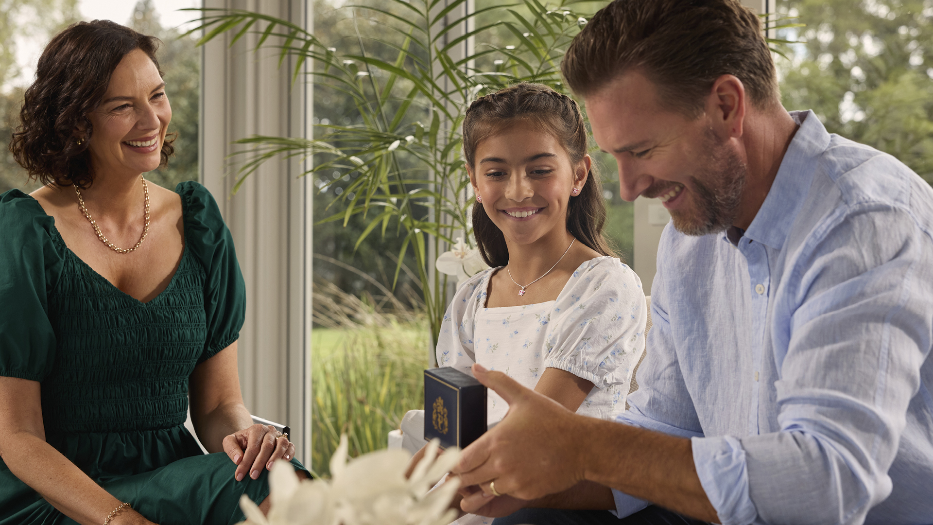 Image of family with father holding a present or text relating to father's day gifting