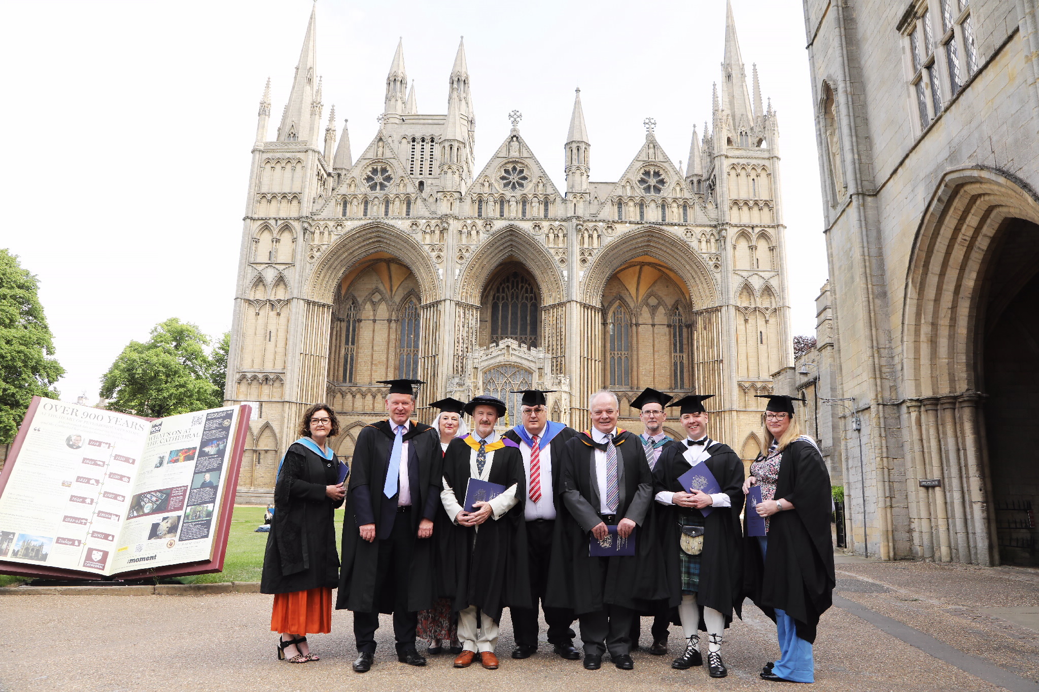 A group of graduates posing in front of the cathedral exterior