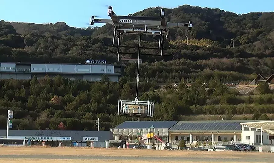 A dual-propeller drone by MHI delivers emergency supplies during a disaster response exercise in Japan
