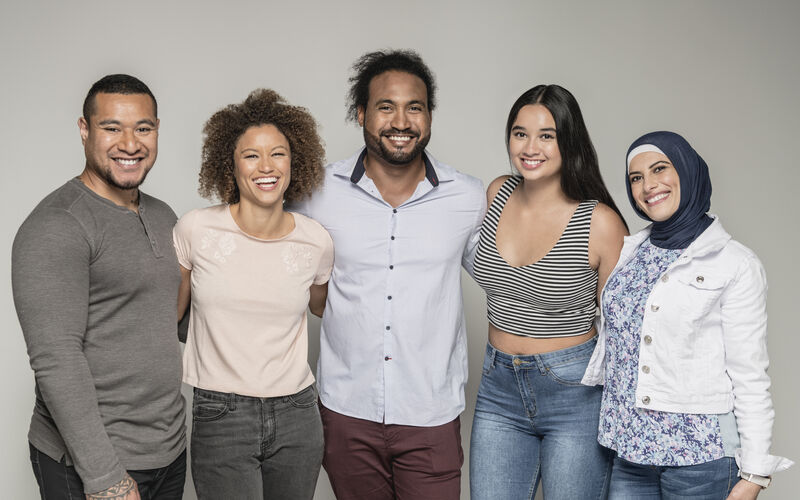 A group of multicultural friends smile at the camera