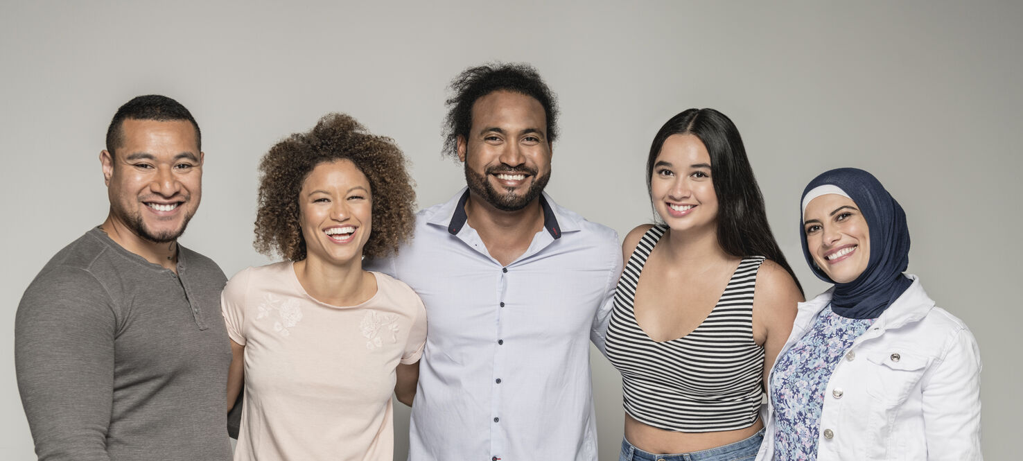 A group of multicultural friends smile at the camera