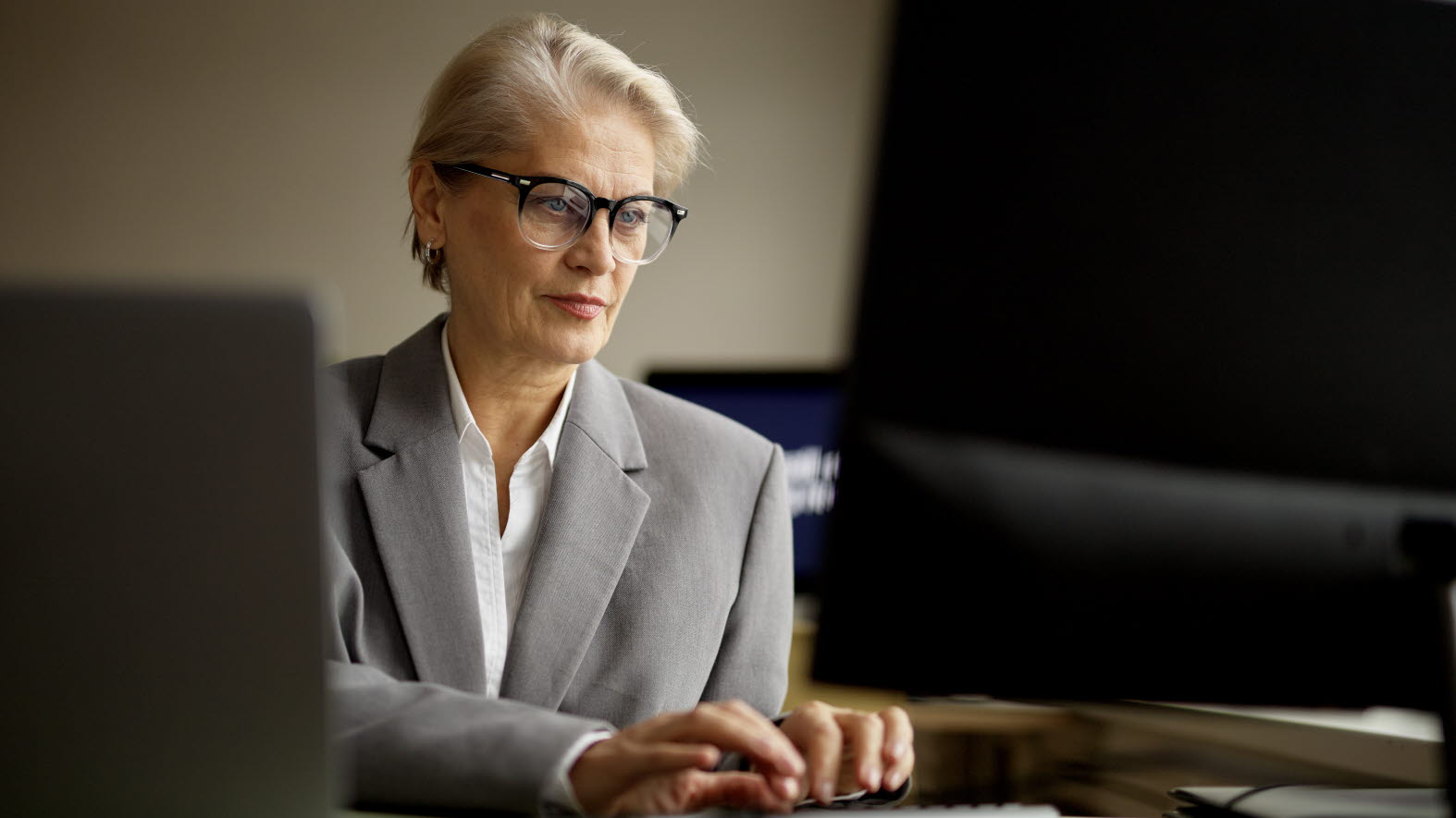 Kvinna vid datorn på kontoret.