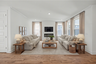 great room with wood flooring, sofas, coffee table, tv, fireplace, and large windows