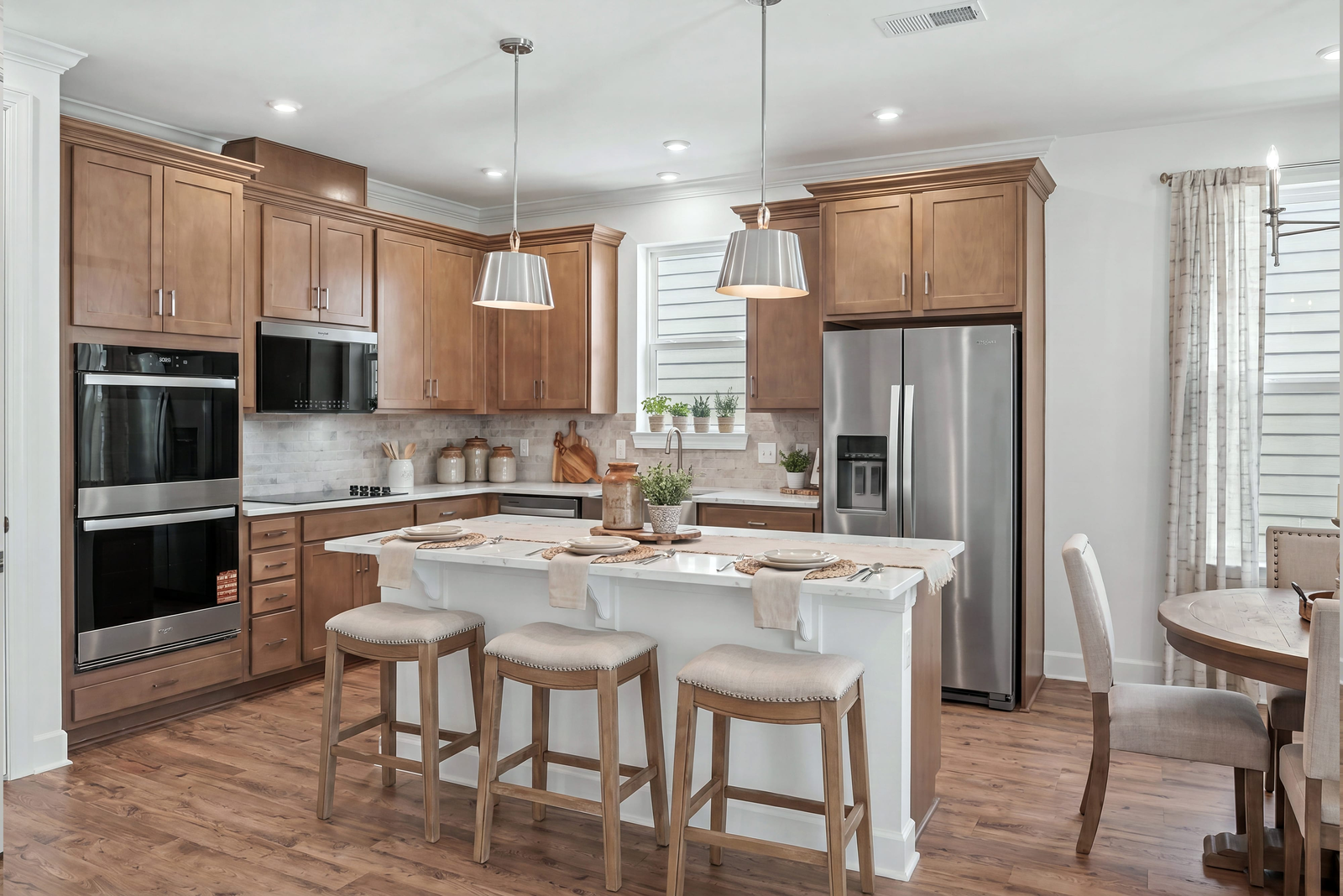 kitchen with wood cabinets, white countertops, stainless steel appliances, barstools, and dining table