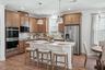 kitchen with wood cabinets, white countertops, stainless steel appliances, barstools, and dining table