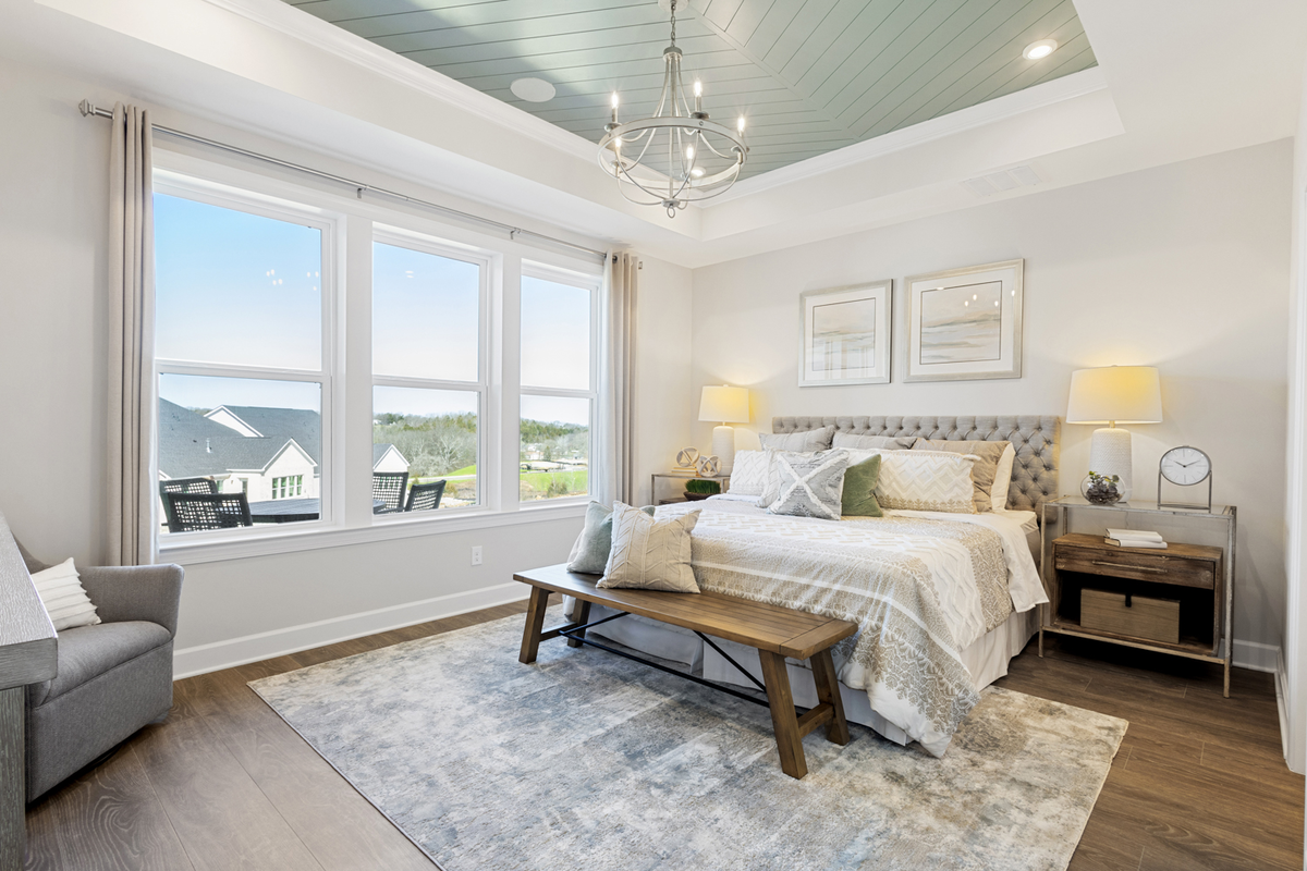 primary bedroom with a tray ceiling