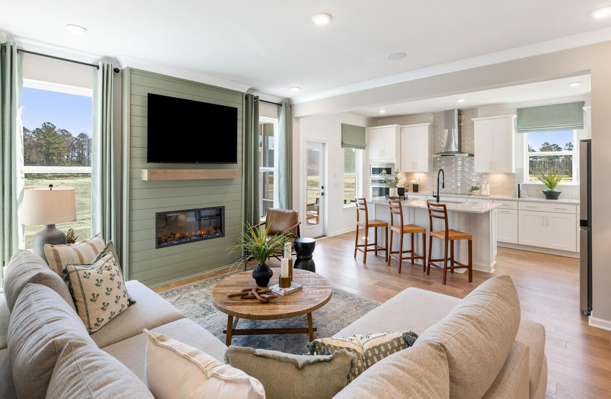 great room with sofa and fireplace open to kitchen