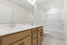 bathroom with dual vanity sinks and wood cabinets