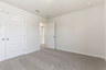 secondary bedroom with large windows, walk in closet, and carpet