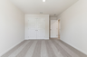 secondary bedroom with large windows, walk in closet, and carpet