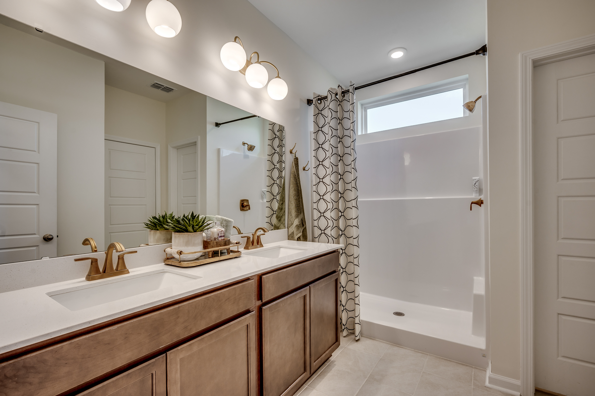 bath with vanity, pendant lights and shower