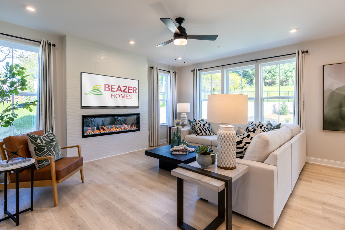 great room with a cream colored couch & fireplace