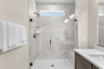bathroom with walk in shower with tile and glass doors