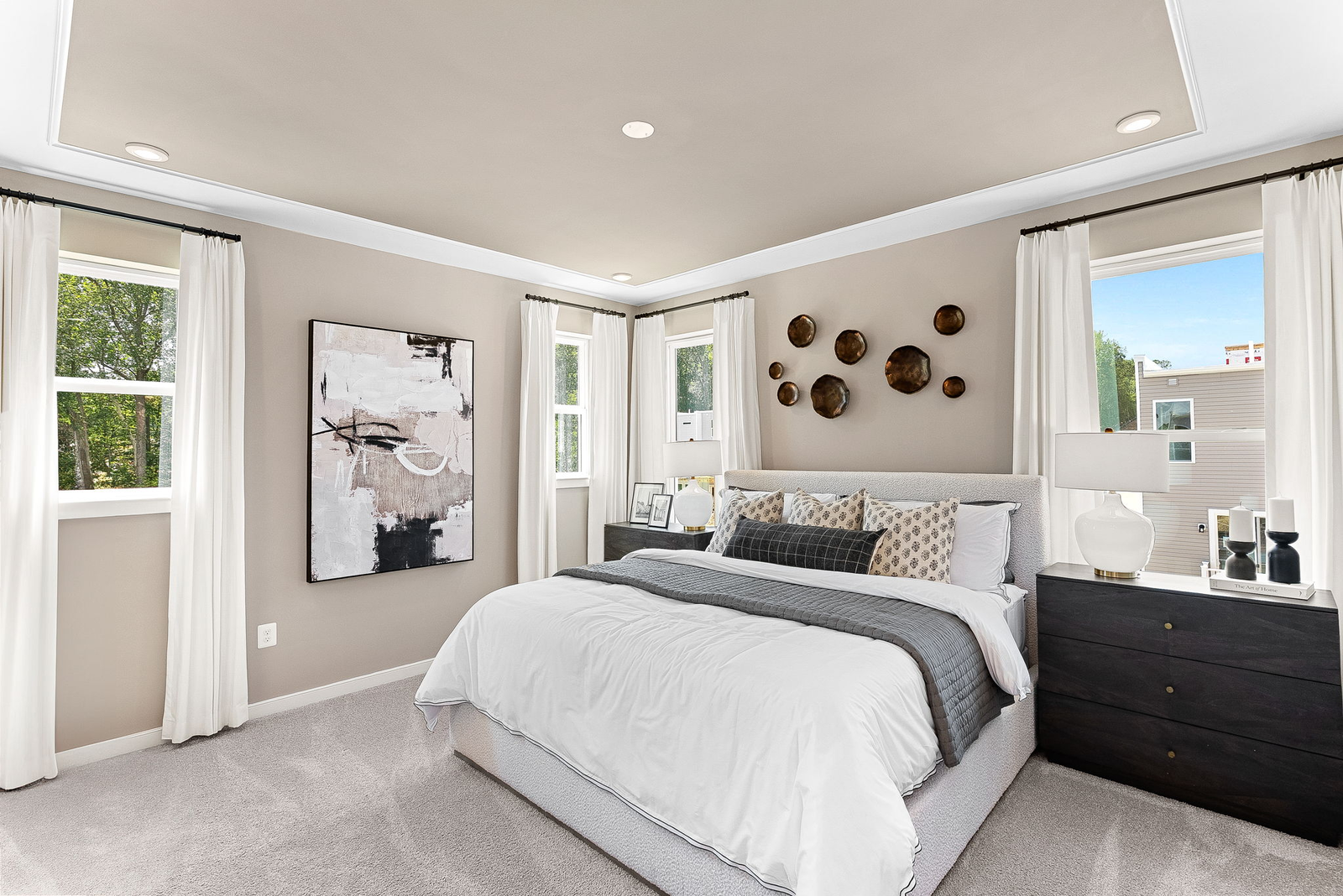 bedroom with painting, large bed and two dressers next to bedsides