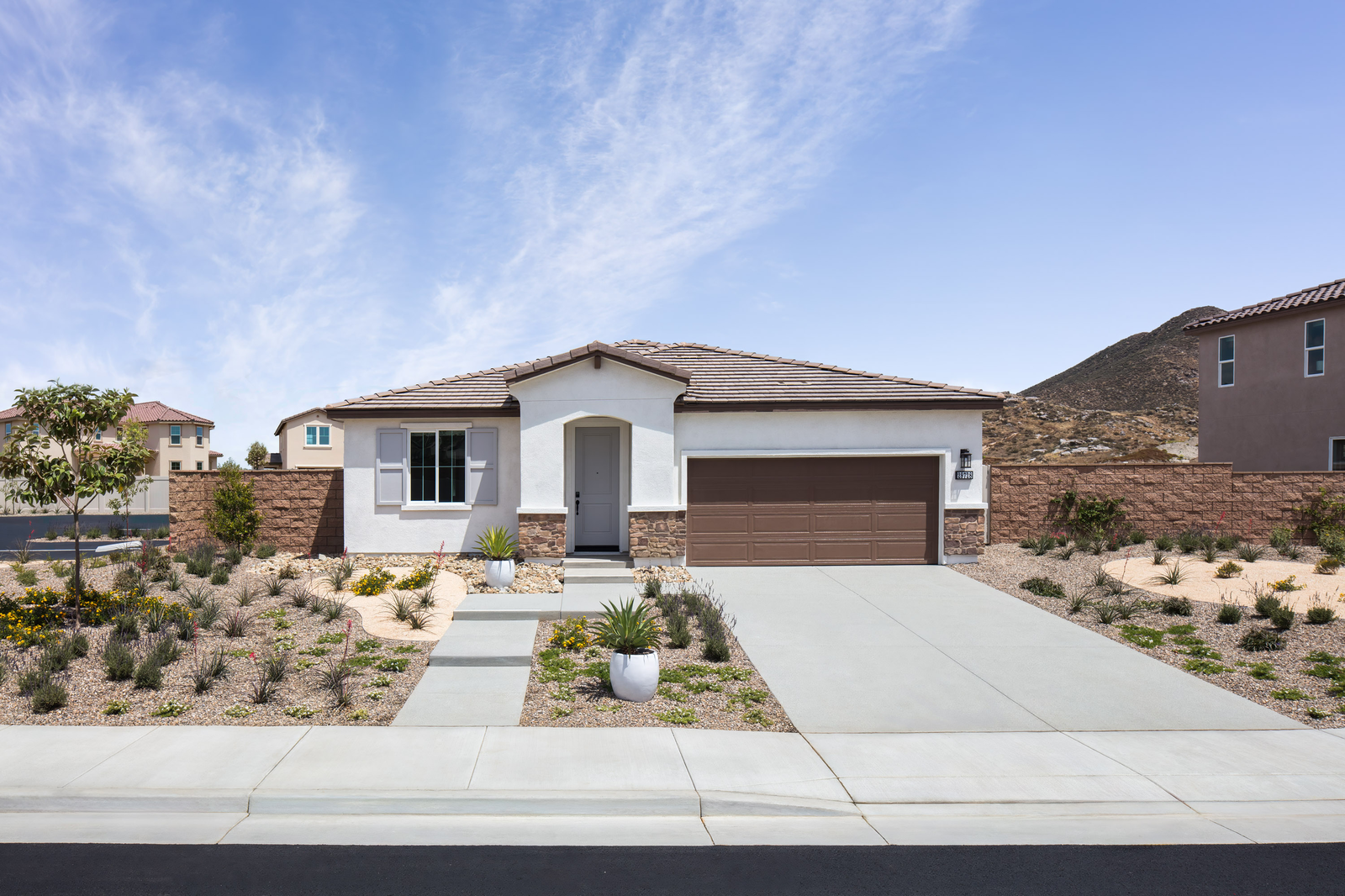 exterior of single-story home with brown garage and desert landscaping