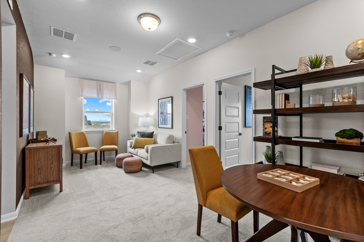 loft with carpet, couches & a table with games