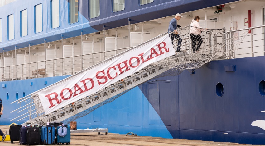 Passengers board the Ocean Albatros with a Road Scholar sign on the gangplank